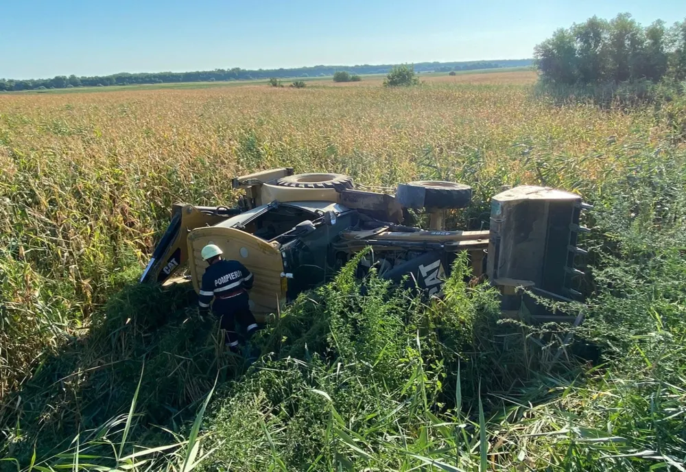 FOTO Buldoexcavator răsturnat pe drumurile din Tulcea. Doi răniți