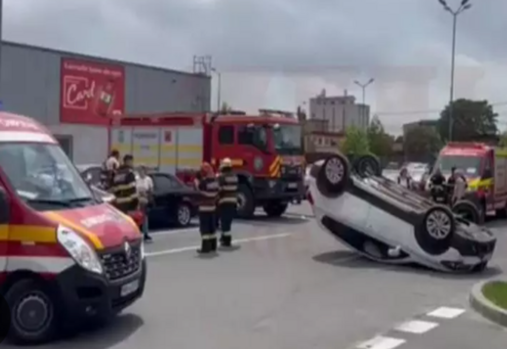 Impact violent în parcare: o mașină răsturnată, o persoană la spital